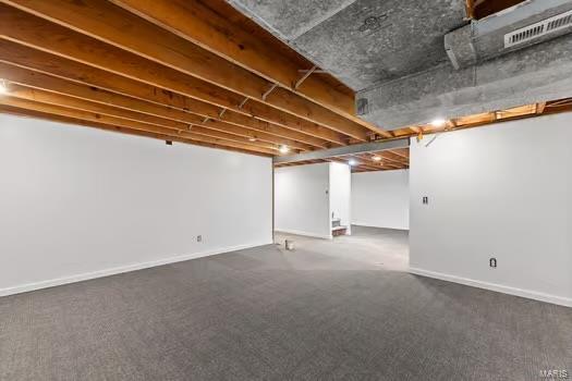 finished below grade area featuring carpet flooring, visible vents, and baseboards