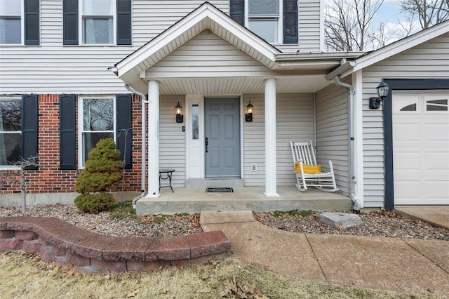 view of exterior entry featuring a porch and a garage