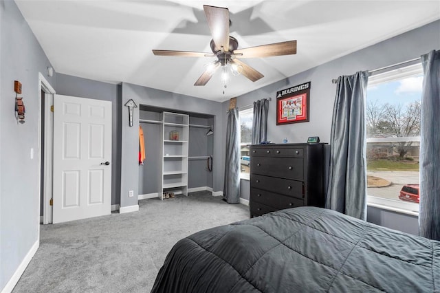 carpeted bedroom with ceiling fan and a closet