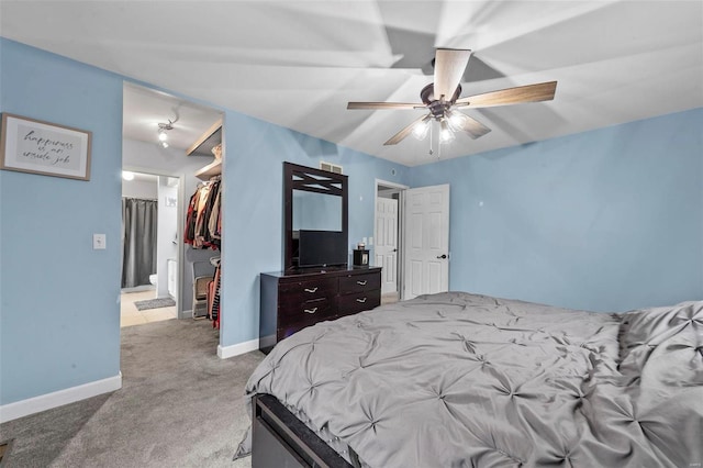 carpeted bedroom featuring ceiling fan, a spacious closet, and a closet