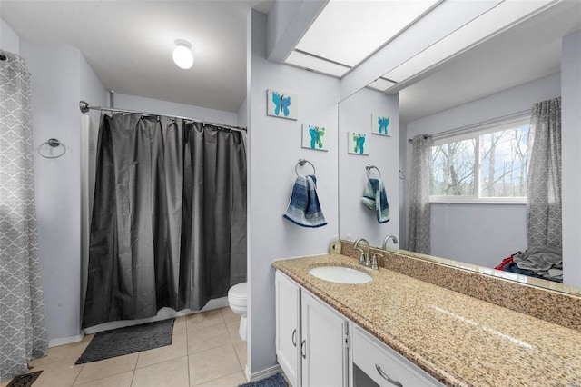 bathroom featuring vanity, a skylight, tile patterned floors, and toilet