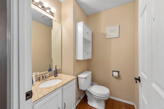 bathroom with vanity, hardwood / wood-style flooring, and toilet