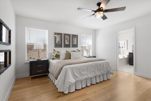 bedroom with baseboards, light wood-style floors, ensuite bath, and a ceiling fan