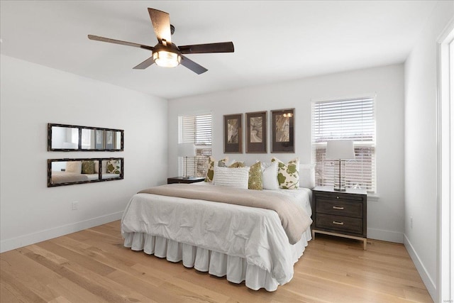 bedroom with light wood-style floors, baseboards, and ceiling fan