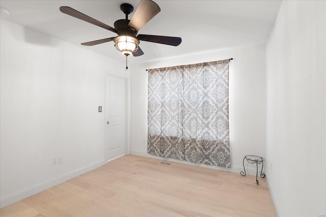 spare room featuring visible vents, baseboards, ceiling fan, and light wood finished floors