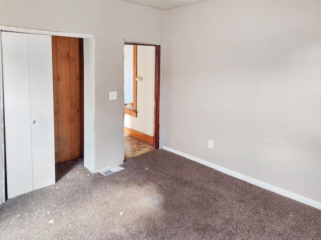 unfurnished bedroom with dark colored carpet