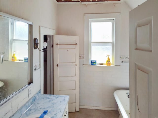 bathroom with a tub to relax in and vanity