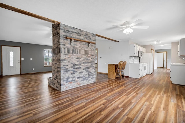 unfurnished living room with wood-type flooring, sink, and ceiling fan