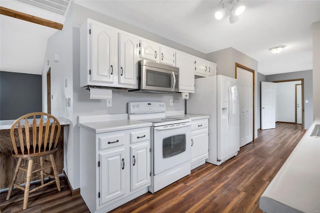 kitchen featuring dark hardwood / wood-style flooring, white appliances, and white cabinets