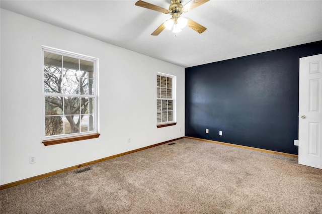 spare room featuring ceiling fan and carpet