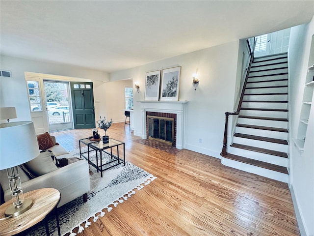 living room with a fireplace and light wood-type flooring