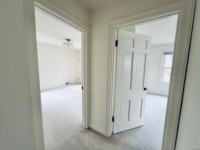 hall featuring light colored carpet