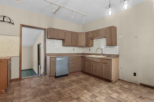 kitchen featuring rail lighting, sink, hanging light fixtures, dishwasher, and backsplash