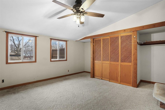 unfurnished bedroom featuring lofted ceiling, light carpet, ceiling fan, and a closet