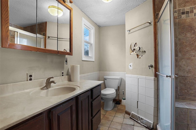 bathroom featuring tile walls, tile patterned flooring, vanity, a textured ceiling, and toilet