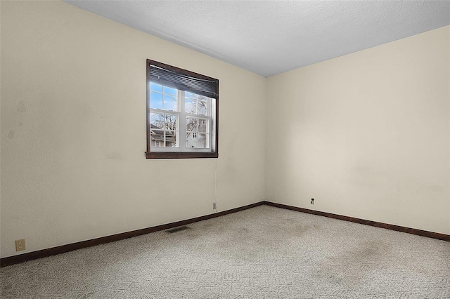 unfurnished room with light colored carpet and a textured ceiling