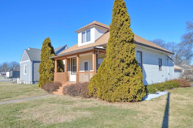 view of home's exterior with a lawn and covered porch