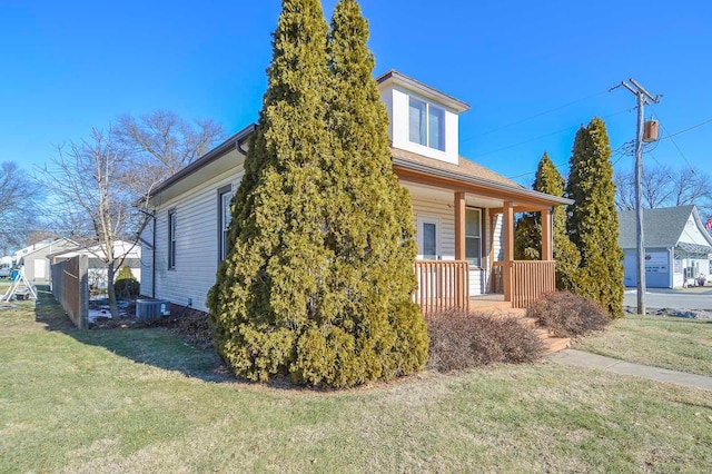 view of side of property with central AC, covered porch, and a lawn