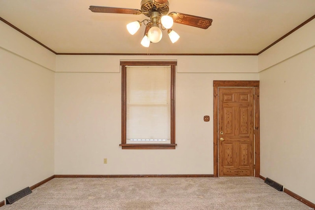 carpeted spare room with crown molding and ceiling fan