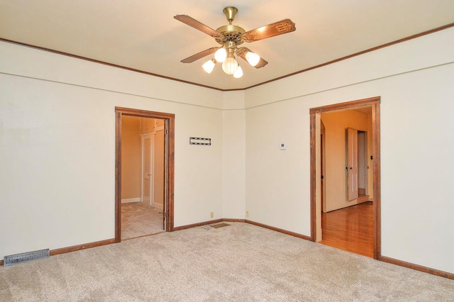 carpeted empty room with ornamental molding and ceiling fan