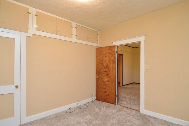 carpeted empty room featuring a textured ceiling