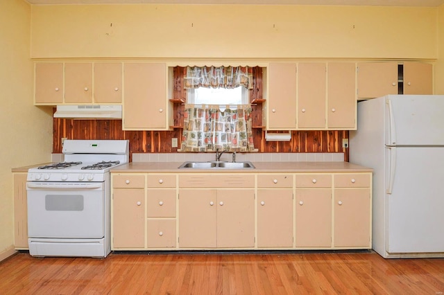 kitchen with sink, white appliances, and light hardwood / wood-style flooring