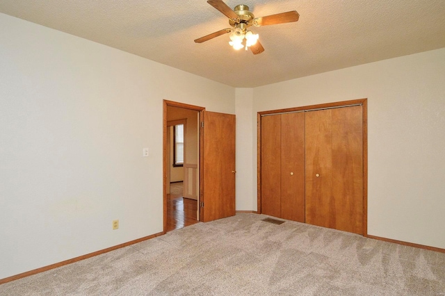 unfurnished bedroom with ceiling fan, a closet, carpet floors, and a textured ceiling