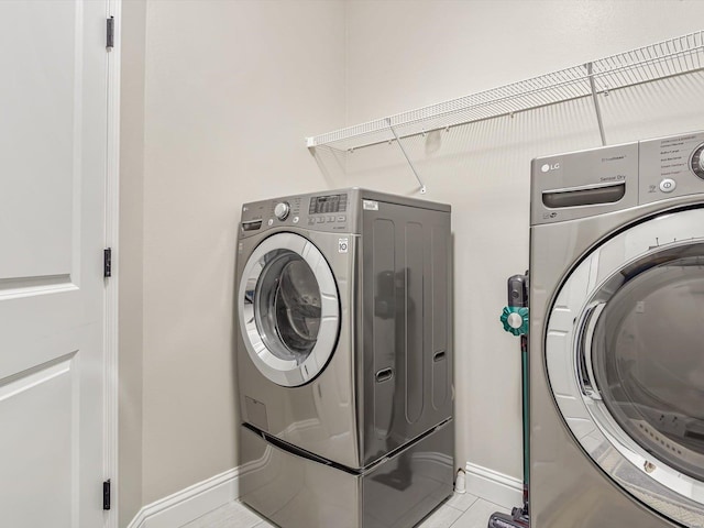 washroom with light tile patterned flooring and washer and clothes dryer