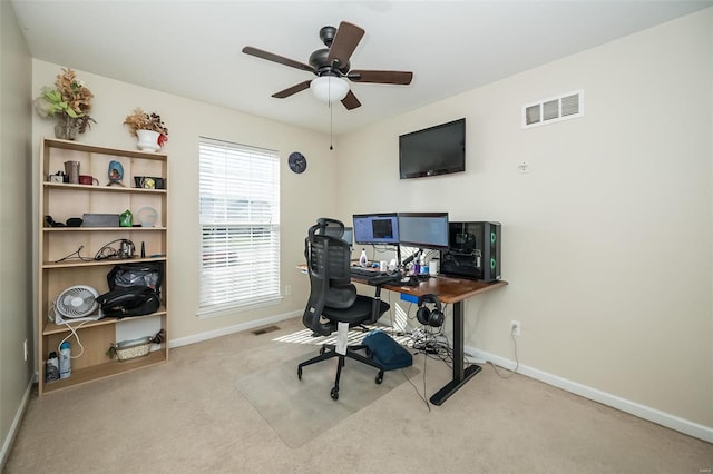 home office featuring baseboards, a ceiling fan, visible vents, and light colored carpet