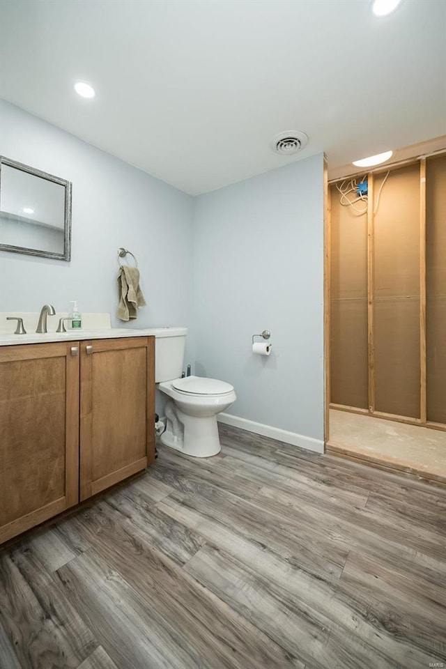 bathroom with visible vents, toilet, and wood finished floors