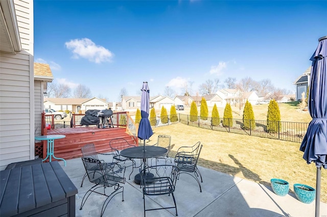 view of patio with outdoor dining space, a fenced backyard, a residential view, and a wooden deck