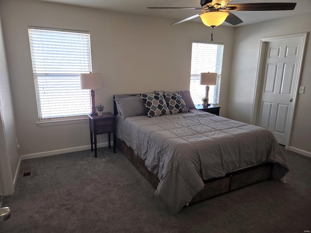 bedroom with visible vents, multiple windows, baseboards, and dark colored carpet