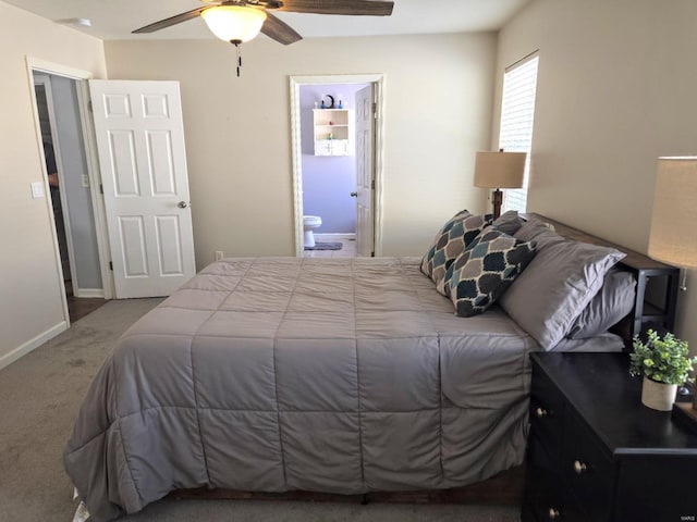 carpeted bedroom featuring ceiling fan, ensuite bath, and baseboards