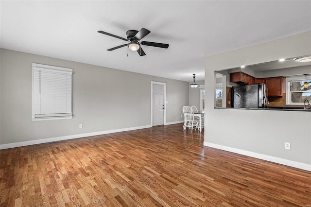 unfurnished living room with hardwood / wood-style flooring and ceiling fan