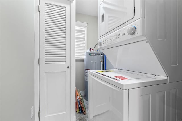 laundry room featuring stacked washer / dryer and electric water heater