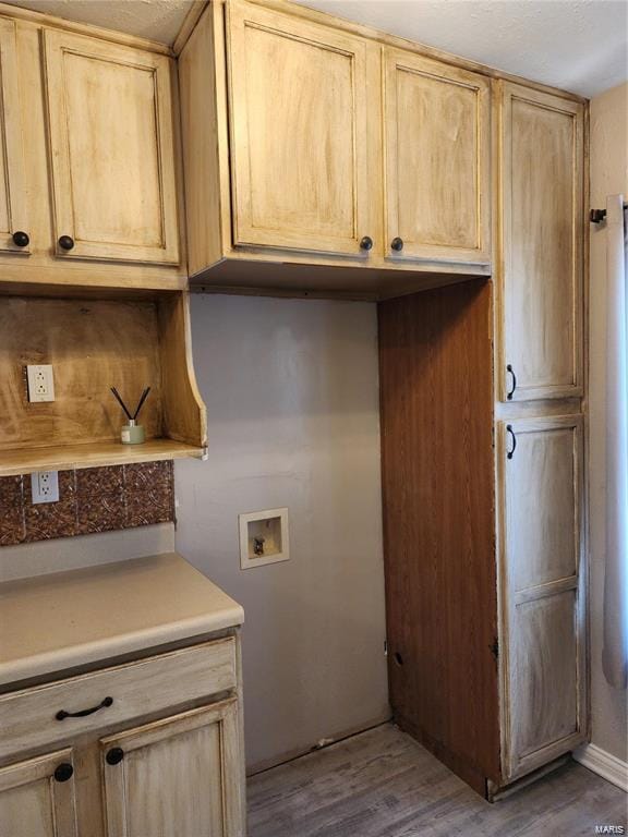 clothes washing area featuring cabinets, wood-type flooring, and hookup for a washing machine