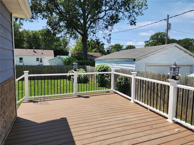 deck featuring a garage and a lawn