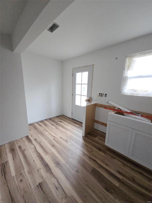 interior space with light hardwood / wood-style floors and white cabinets