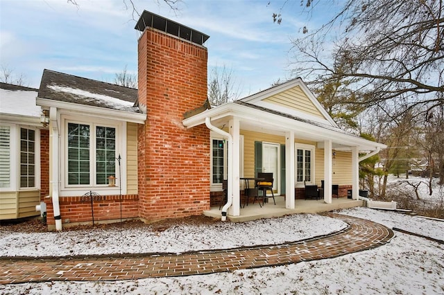 snow covered property featuring a porch