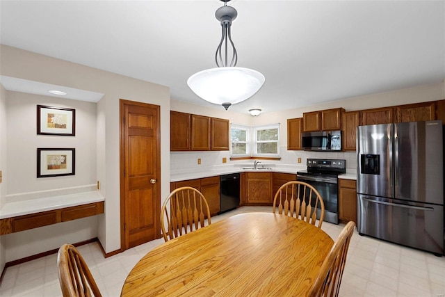 kitchen with tasteful backsplash, sink, decorative light fixtures, and appliances with stainless steel finishes