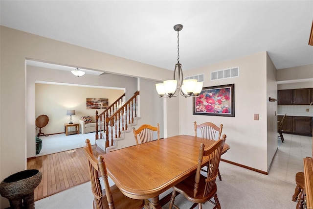 dining area with light colored carpet and a chandelier