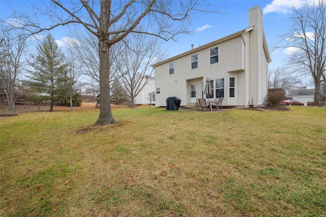 rear view of property featuring a yard and a patio area