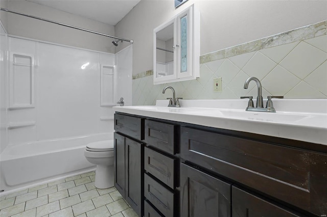 full bathroom with tile walls, vanity, toilet, bathing tub / shower combination, and tile patterned floors