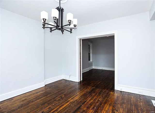 unfurnished dining area featuring a notable chandelier and dark wood-type flooring