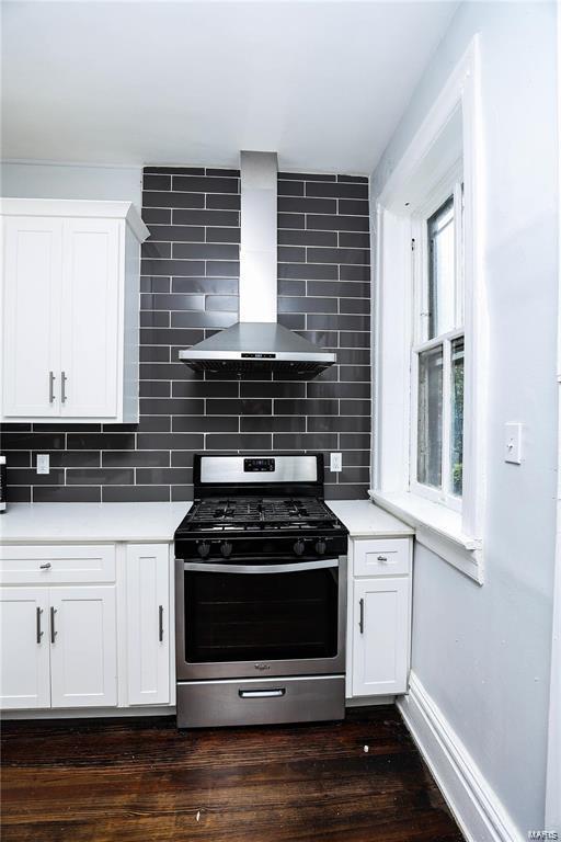 kitchen featuring white cabinetry, wall chimney range hood, decorative backsplash, and stainless steel range with gas cooktop