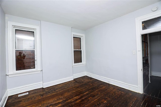 spare room with dark hardwood / wood-style flooring