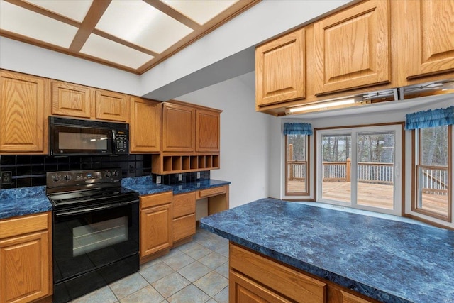 kitchen featuring backsplash, built in desk, light tile patterned floors, and black appliances