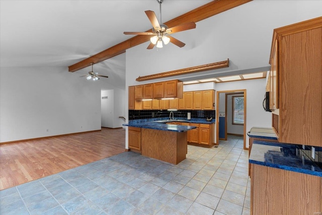 kitchen with light tile patterned floors, ceiling fan, beam ceiling, tasteful backsplash, and kitchen peninsula