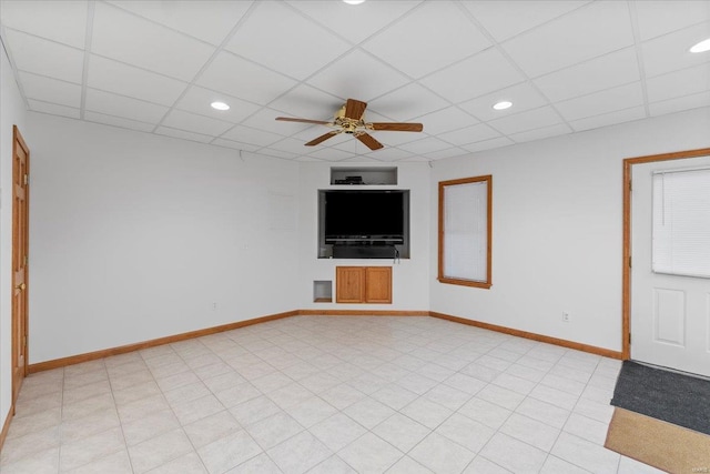 unfurnished living room with ceiling fan and a drop ceiling