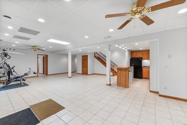 interior space with light tile patterned floors, a drop ceiling, and ceiling fan